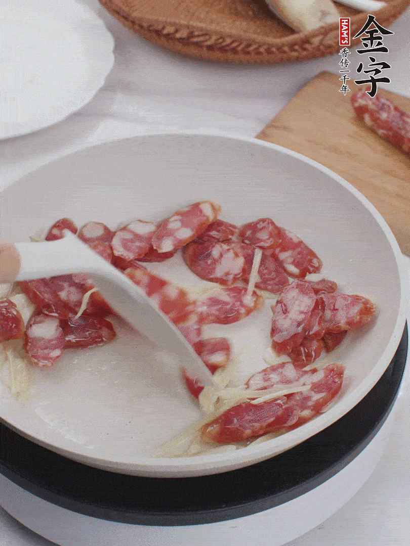 油溫3成熱時，下姜絲、蒜片、香腸炒出油脂。