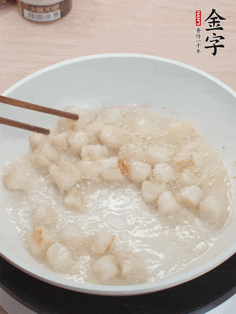 油溫4成熱，鮮貝蘸干淀粉下鍋煎，一面微黃后翻面。