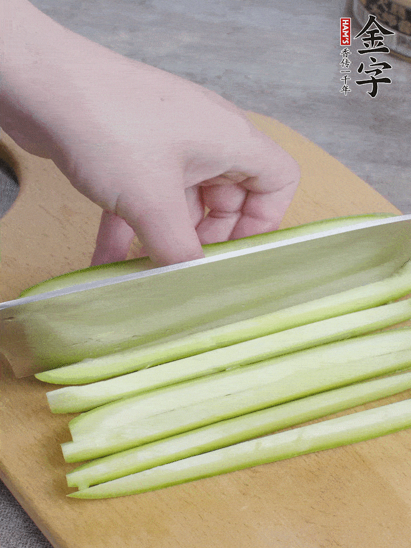 西葫蘆對(duì)半切，去瓤切條。