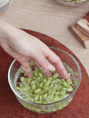 青豆剝殼，搓去外衣。