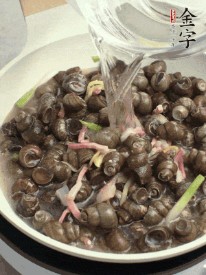 倒處理干凈的螺螄翻炒，加3勺料酒。加清水蓋過螺螄，中火蓋蓋煮5分鐘。
