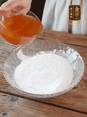 轉(zhuǎn)化糖漿、枧水、花生油攪拌均勻，加入面粉混合，醒發(fā)2小時。捏成23g一個的小球